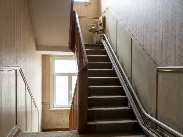 Rechte trap met traplift in de smalle gang van een rijwoning